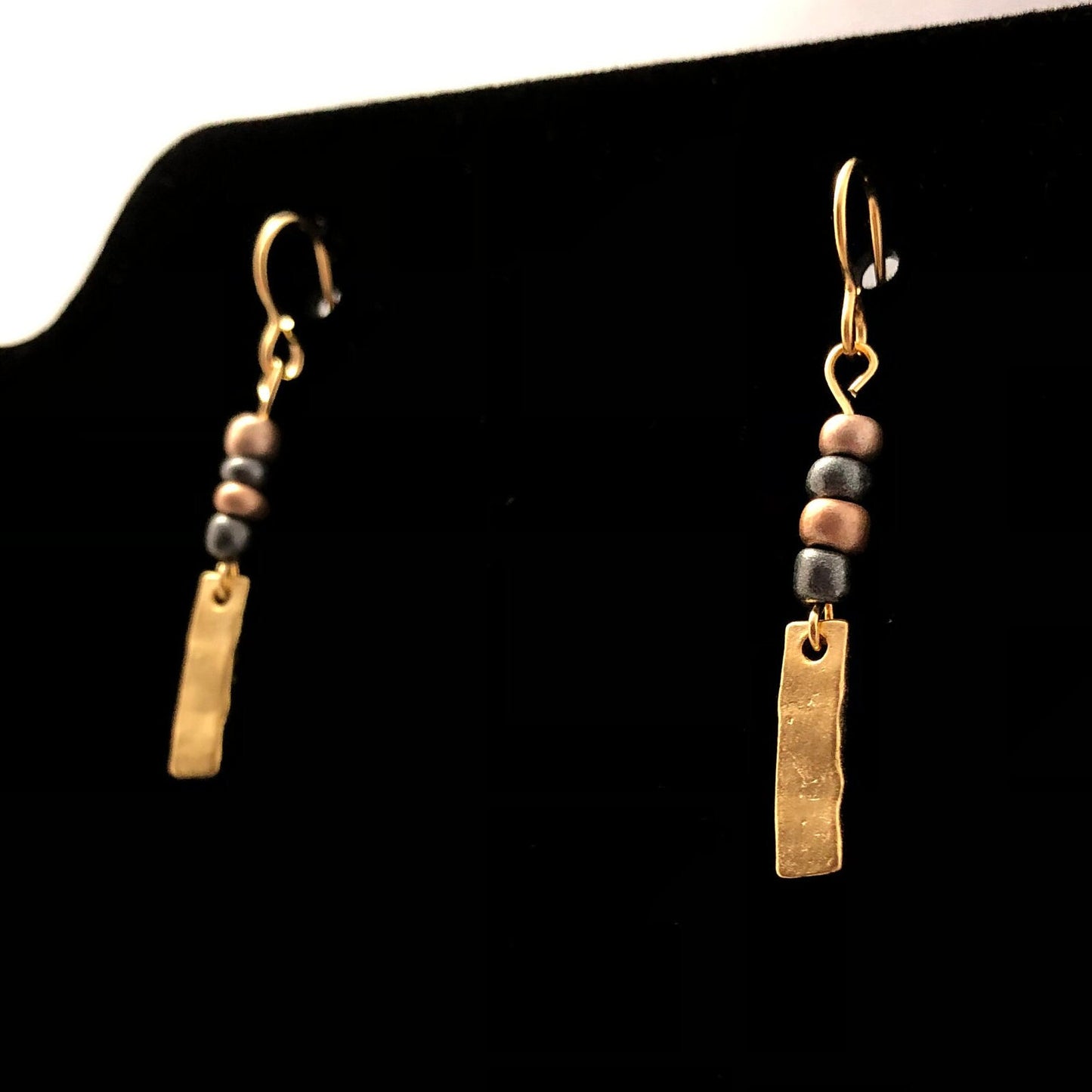 Mixed media dangling earrings made with slender brass charm below combination of 4 glass & beads between them attached to brass hook