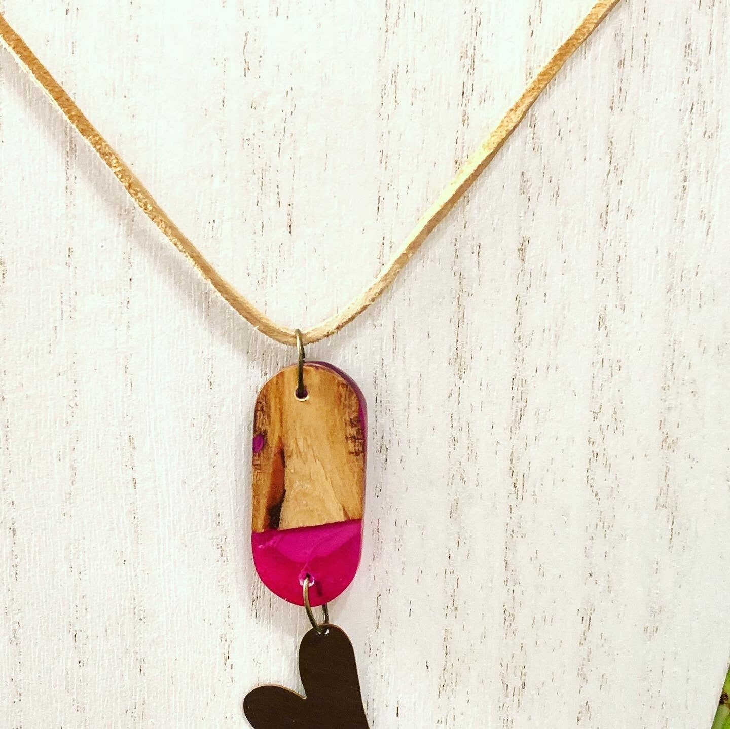 Red resin and wood pendant with copper heart charm attached, suspended on Beige leather/suede necklace.