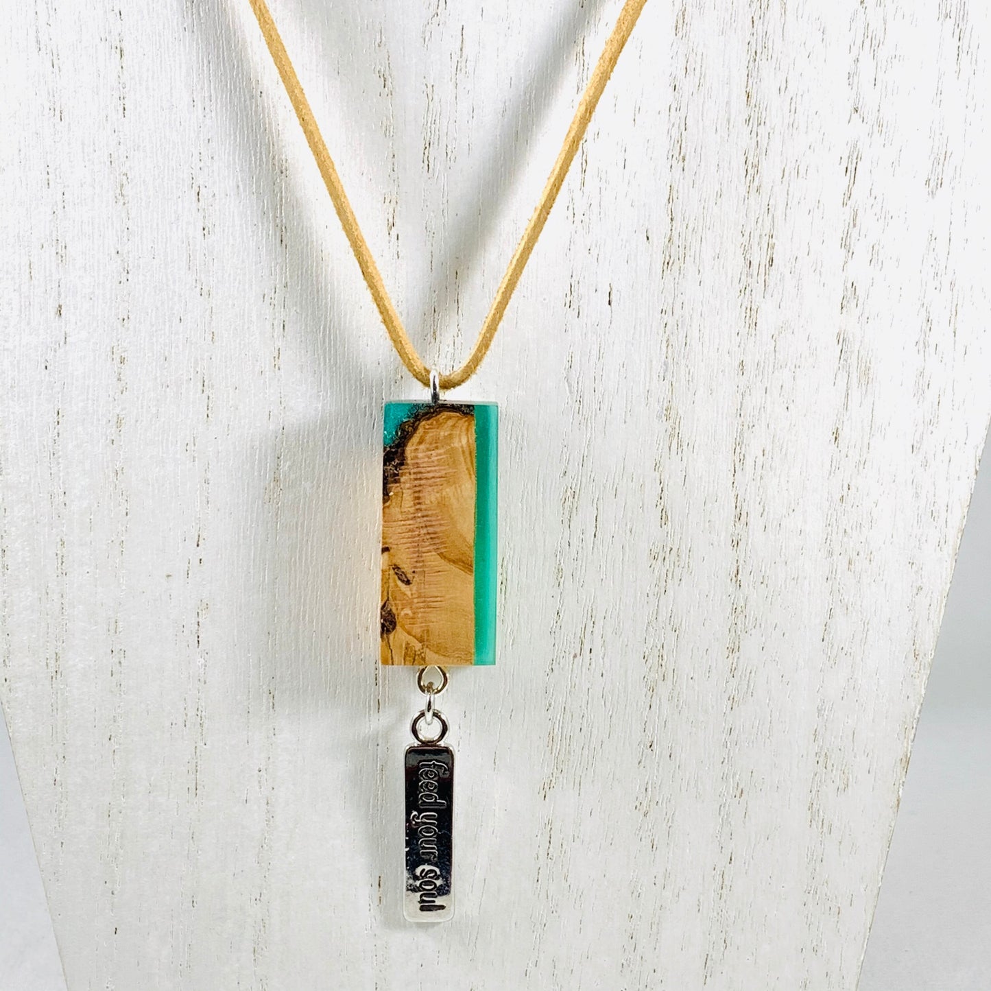 Green Resin and Wood pendant necklace with Feed Your Soul Charm hanging from beige suede necklace.